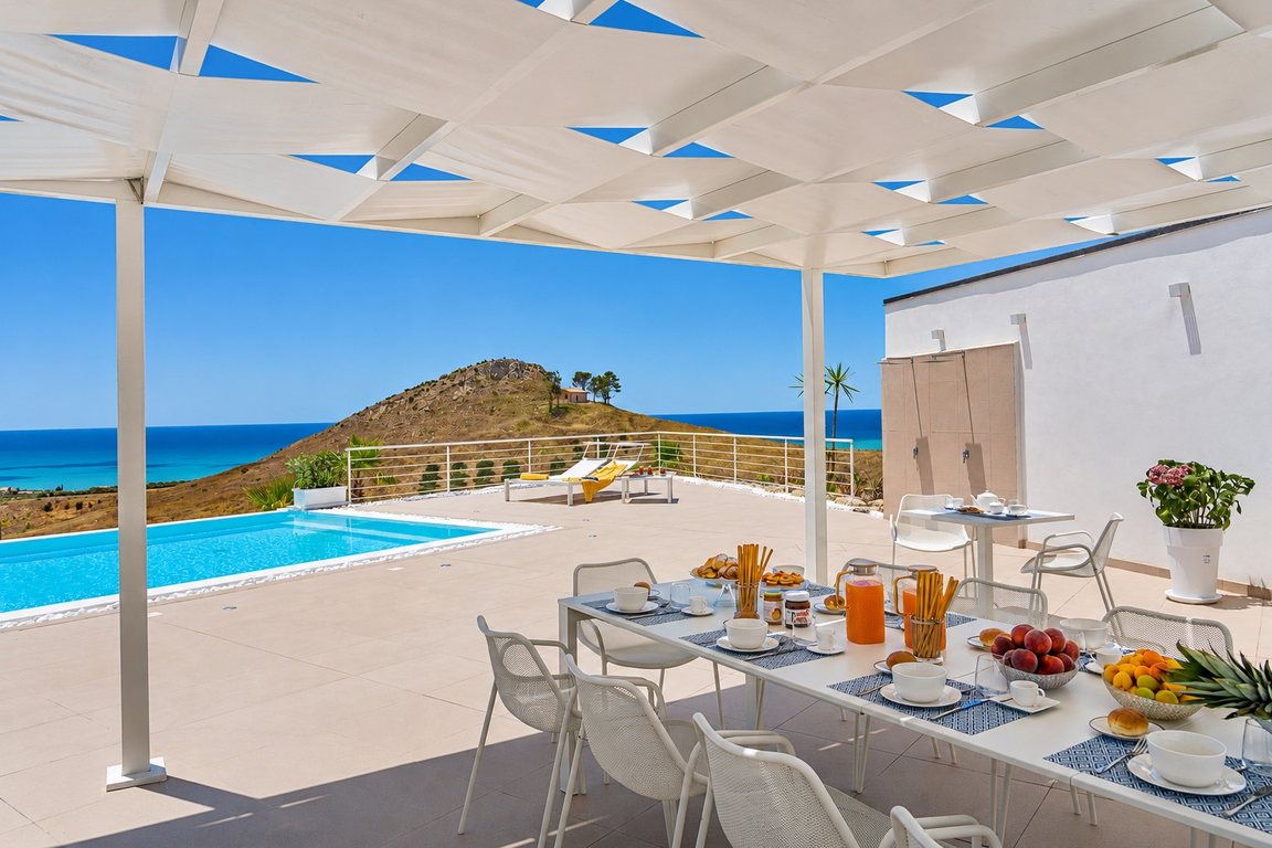 La colazione sotto il pergolato, con la vista sulla collina e sul mare
