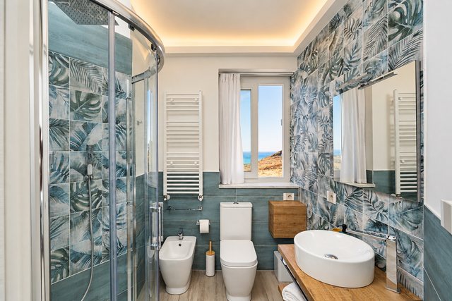 Un bagno con la doccia e il lavabo in appoggio